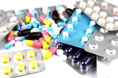 Pills of many shapes and colors grouped together
