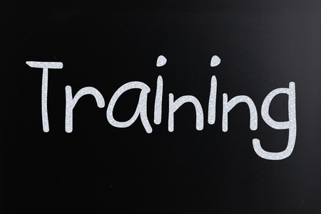 The word "Training" handwritten with white chalk on a blackboardの写真素材