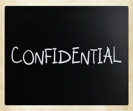 The word "Confidential" handwritten with white chalk on a blackboardの写真素材