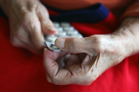 Close up of old hands with tablets.の写真素材