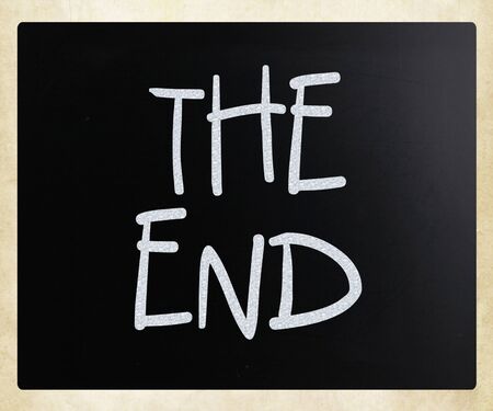 The End handwritten with white chalk on a blackboard.の写真素材