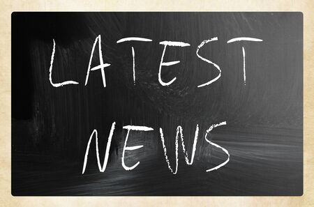 "Latest news" handwritten with white chalk on a blackboardの写真素材