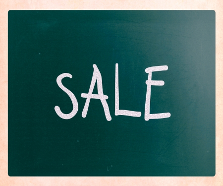 "Sale" handwritten with white chalk on a blackboardの写真素材