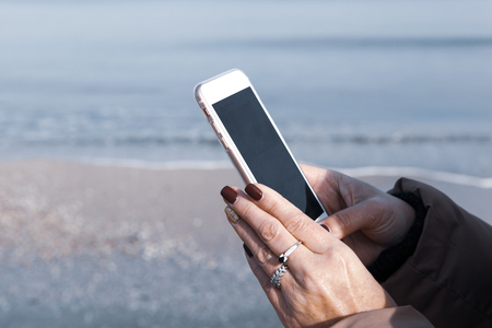 Beautiful Woman Using Smart Phone On A Beachの写真素材
