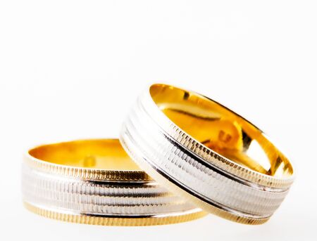 Close-Up Of Gold Wedding Rings Against White Backgroundの写真素材