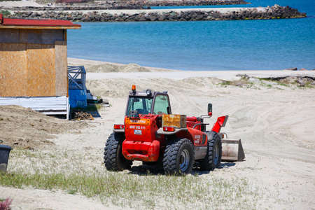 Pomorie, Bulgaria - May 09, 2020: Preparing for the new season. Construction machine on the beach