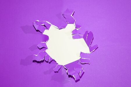 Hole in the blue paper with rend sidesの写真素材