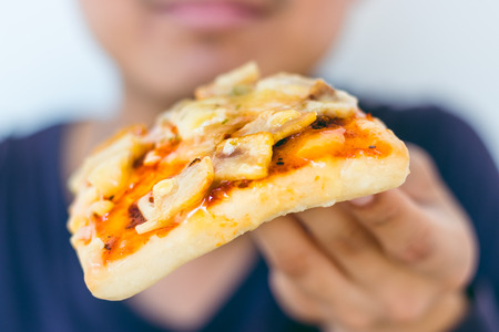 Cloes up Happy hungry young man eating a piece of pizza.の写真素材