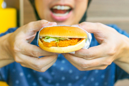 So good young man eats him delicious appetizing chicken burger. delicious burger.の写真素材