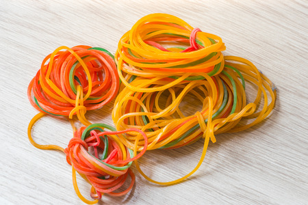 The colorful loom bands on wood background, plastic bandの写真素材
