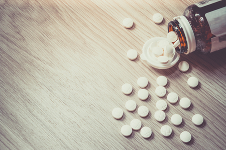 Pills Bottle with Vitamins inside on wood background , zinc , vitamins a, multivitamins.の写真素材