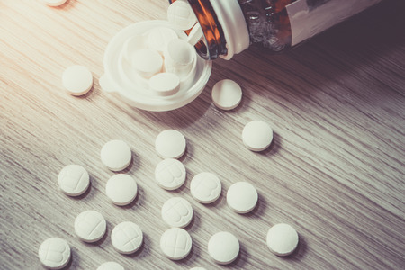 Pills Bottle with Vitamins inside on wood background , zinc , vitamins a, multivitamins.の写真素材