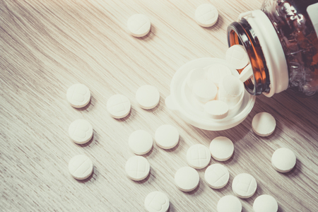 Pills Bottle with Vitamins inside on wood background , zinc , vitamins a, multivitamins.の写真素材