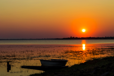 Sunset on the lake  with a boat in buriram, thailand.の写真素材