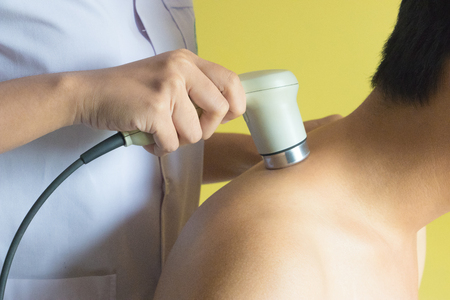 Physicaltherapist using ultrasound probe on patient shoulder for release pain.の写真素材