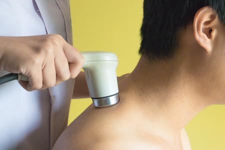 Physicaltherapist using ultrasound probe on patient shoulder for release pain.の写真素材