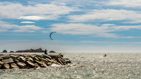people watching a kite surfer in action on french riviera in saint raphael, franceの写真素材