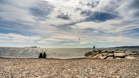 people watching a kite surfer in action on french riviera in saint raphael, franceの写真素材