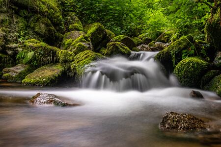 long exposure shot of a tiny waterfall in black forest, germanyの写真素材
