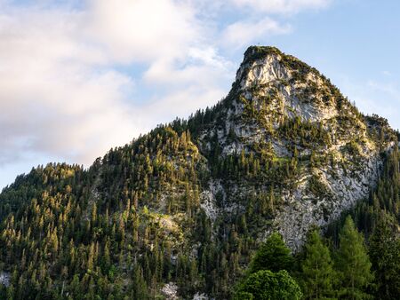 sunlight during sunset illuminates the peak of kofel in Oberammergau, germanyの写真素材
