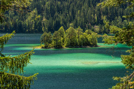 View on beautiful island in the eibsee in front of the zugspitze mountain, bavaria, germanyの写真素材
