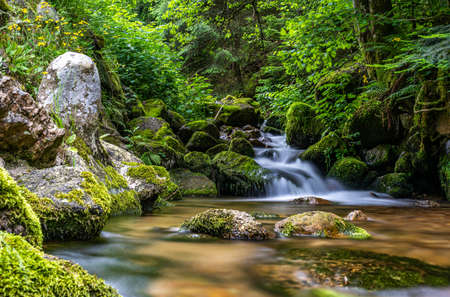 long exposure shot of a tiny waterfall in black forest, Germanyの写真素材