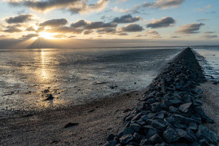 View on the wadden sea of the north sea at low tide at sunset near Bernersiel, Germanyの写真素材
