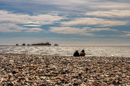 people watching waves of mediterranean sea at french riviera in saint raphael, franceの写真素材