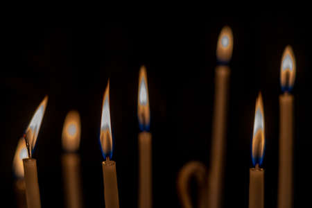closeup of multiple burning candles with beautiful bokeh in churchの写真素材