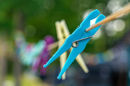 Many plastics clothes pin on washing line with bokeh backgroundの写真素材
