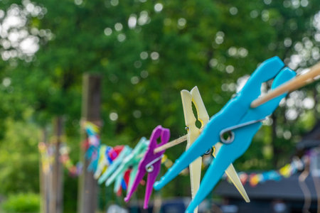Many plastics clothes pin on washing line with bokeh backgroundの写真素材