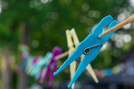 Many plastics clothes pin on washing line with bokeh backgroundの写真素材
