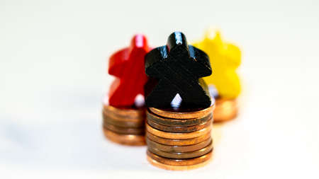 illustration of compentition in financial market with wooden figurines and coinsの写真素材