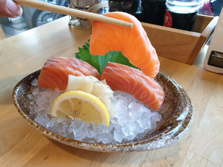 Picking up a slice of salmon sashimiの素材