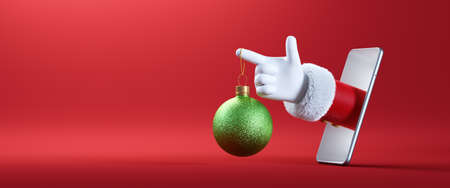 3d render. Cartoon character Santa Claus hand holds green hanging glass ball ornament, sticking out the smartphone screen. Christmas festive banner with red backgroundの写真素材