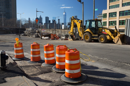 Brooklyn, New York - USA - July 10 2016: Construction site with orange cones and backhoe with world...