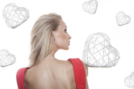 Blonde young beautiful woman with hearts on white background の写真素材