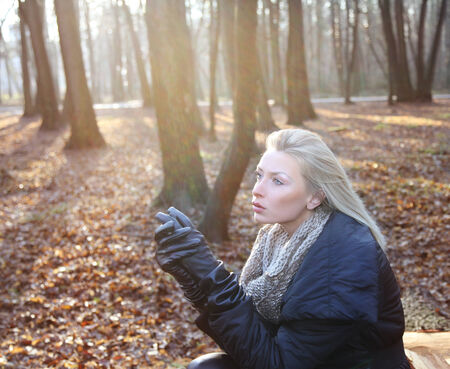 Portrait of beautiful blonde girl posing in forest. Woman looking away.の写真素材