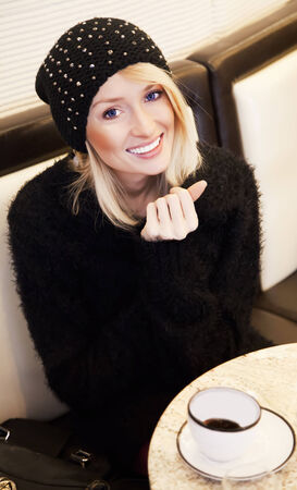 Beautiful blonde young woman relaxing, drinking coffe. Portrait.の写真素材