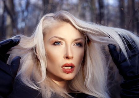 Beautiful blonde young woman posing, looking away. Portrait photo, outdoor.の写真素材