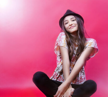 Young smiling brunette girl posing in studio, looking at camera.の写真素材