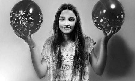 Young beautiful brunette teenager posing with baloons. Girl in studio.の写真素材