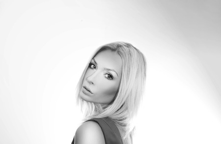 Sensual blonde beautiful woman posing wearing red dress, looking at camera.の写真素材