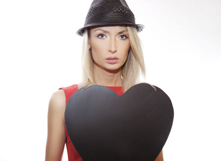 Portrait of beautiful attractive blonde womanwith heart, girl looking at camera.の写真素材