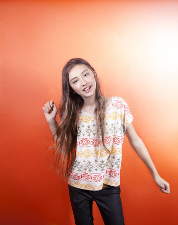 Dancing young teenager girl looking at camera. Studio shot. の写真素材
