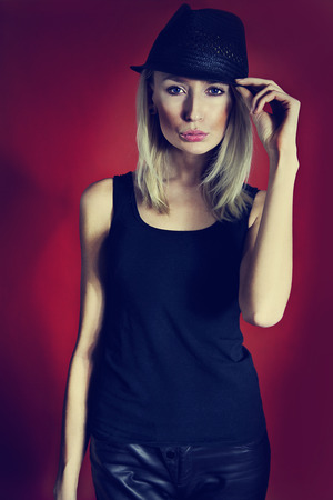Blonde attractive woman posing in studio, wearing hat.の写真素材