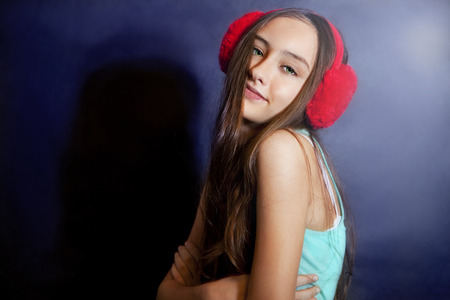 Young teenager girl listening music, looking at camera.の写真素材