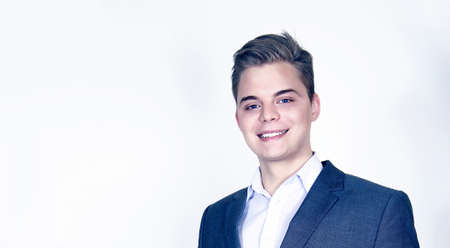 Handsome young businessman posing, smiling, looking at camera.の写真素材