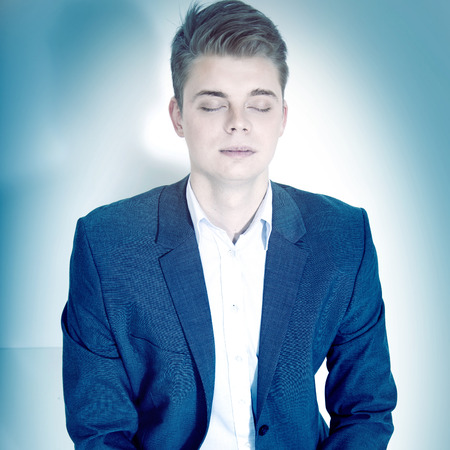 Young businessman posing, relaxing. Conceptual photo in studio.の写真素材