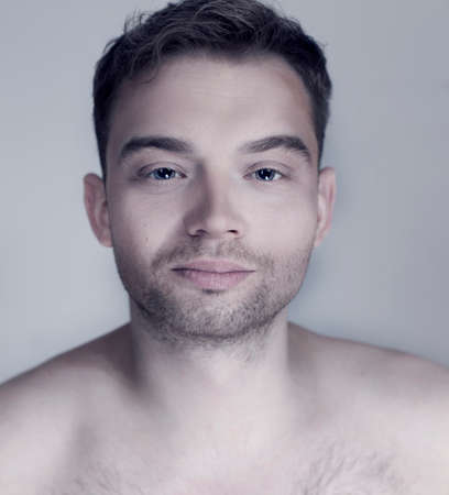 Portrait of young handsome calm man looking at camera. Studio shot.の写真素材